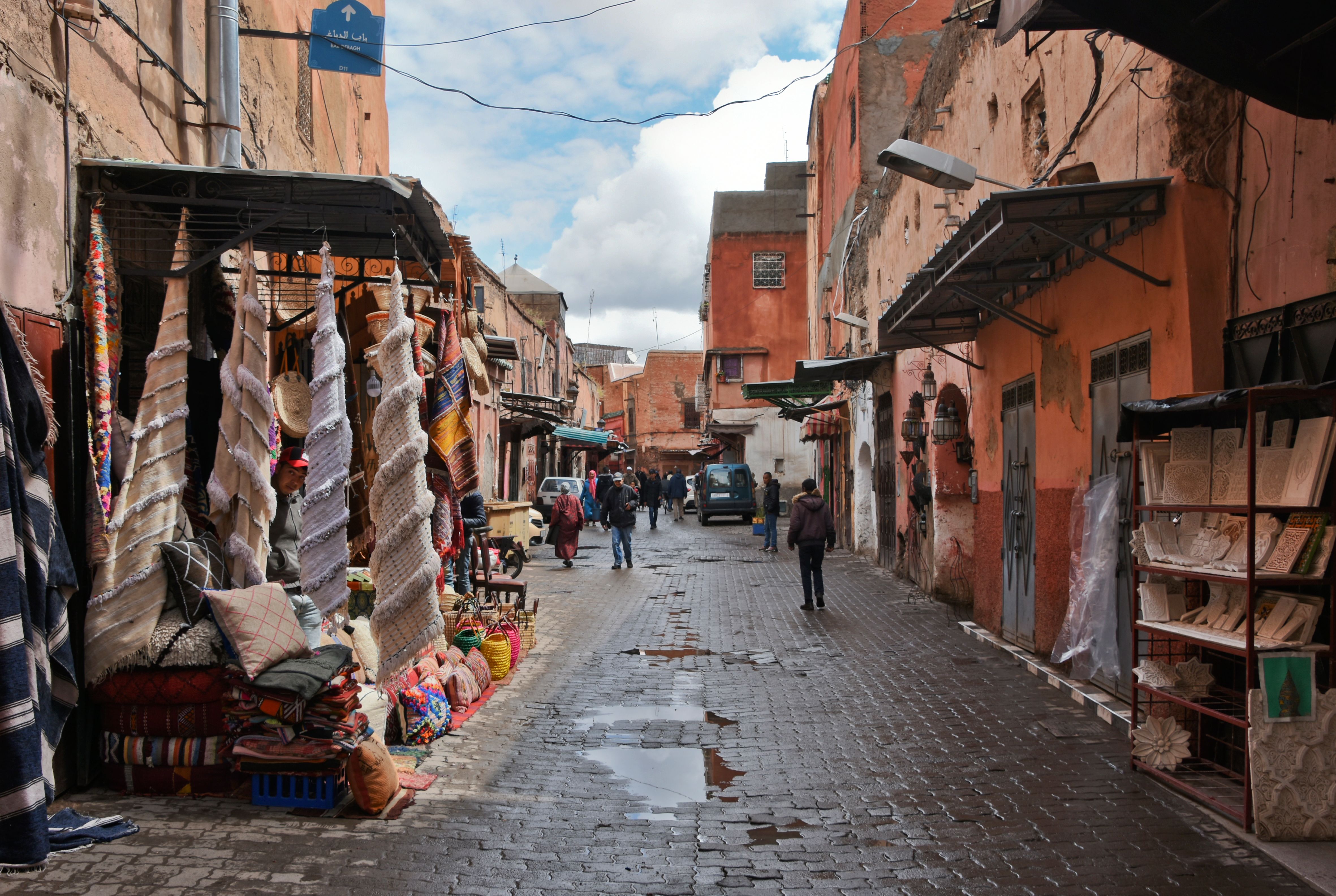 Colorful Marrakech market with vibrant fabrics and traditional Moroccan architecture.