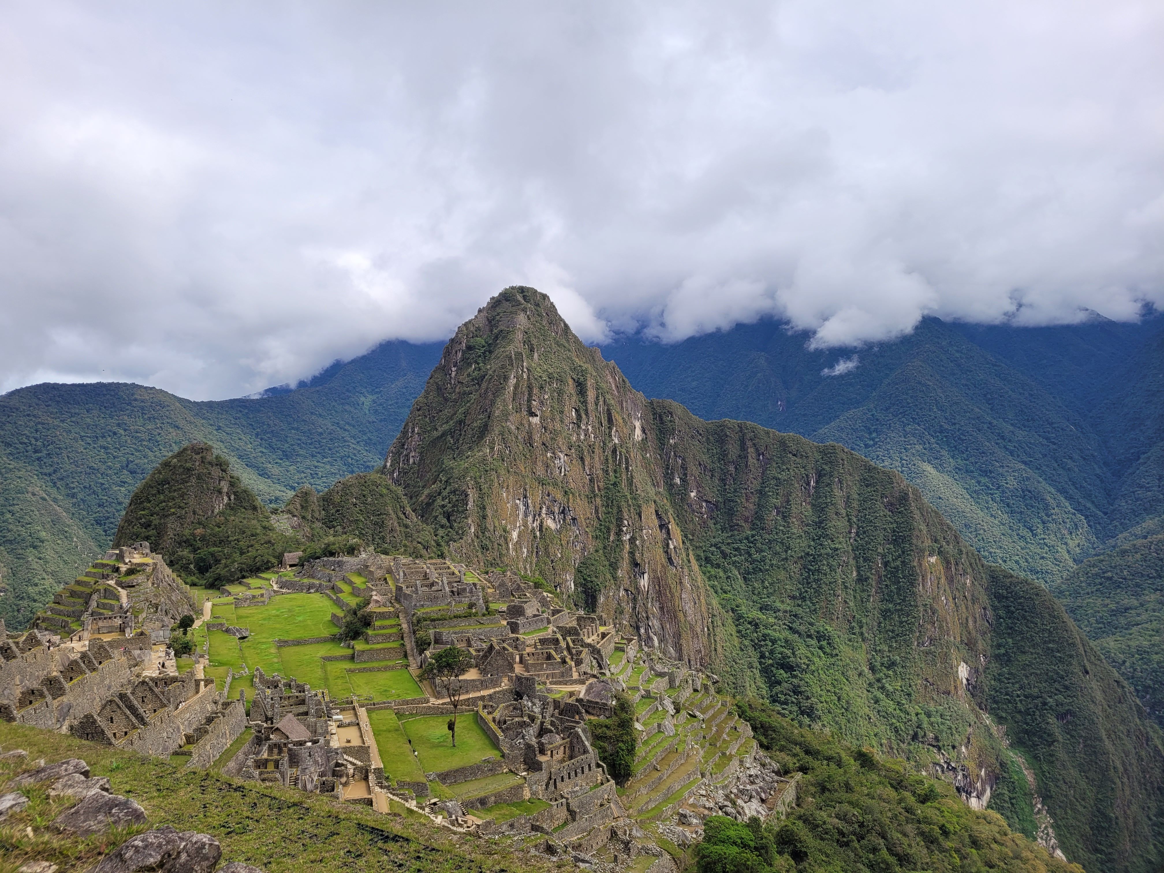 Aerial view of Machu Picchu's Inca ruins among the lush peaks of the Peruvian Andes.
