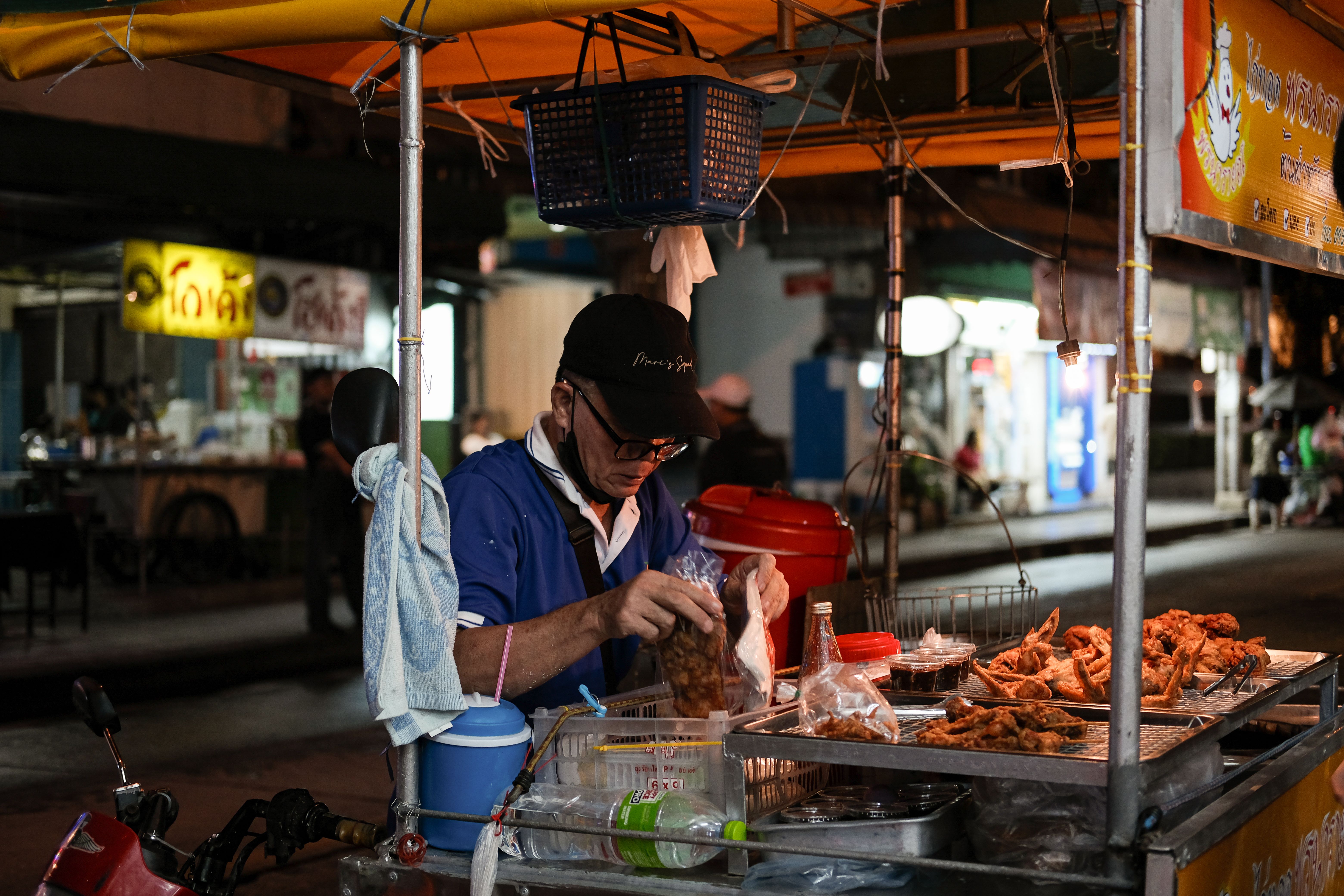 Bangkok street-food vendor cooking at a lively night market in Thailand.